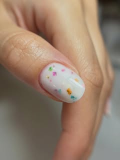 Beli nokti sa šarenim konfeti nail art detaljima